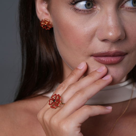 Amour toujours Close-up of a woman wearing a red floral ring with a gray background