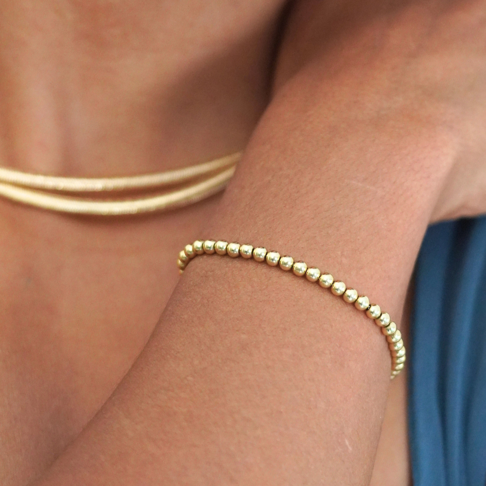 Gold bracelet on a wrist with a blurred background