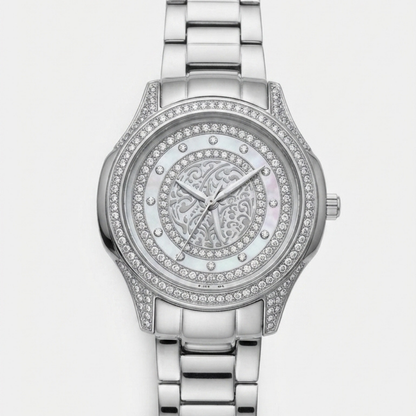 A Tony Valentino silver-tone metal link bracelet watch with a round bezel and dial encrusted with clear rhinestones, featuring a central mother-of-pearl style dial with an ornate monogram design.