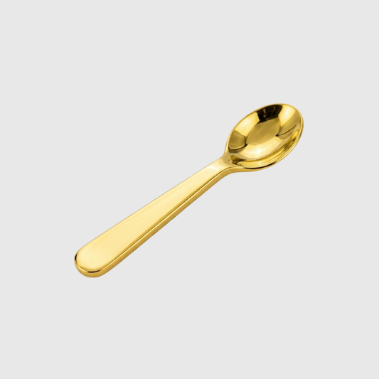 Gold spoon on a light gray background
