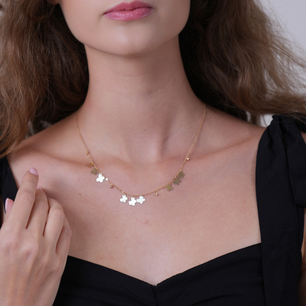Butterflies charms – small necklace
A close-up of a woman wearing a delicate gold necklace with small butterfly charms, paired with a black top.