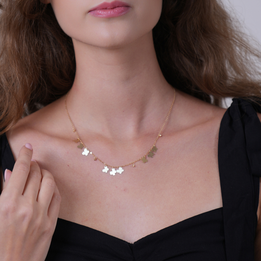 Butterflies charms – small necklace
A close-up of a woman wearing a delicate gold necklace with small butterfly charms, paired with a black top.