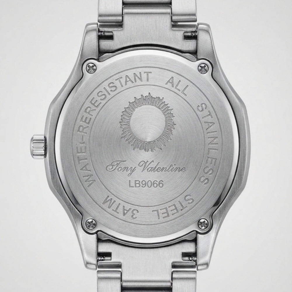 Tony Valentino Close-up of the back of a stainless steel wristwatch with a metal link band, showing engraved text and a sunburst logo on a light gray background.