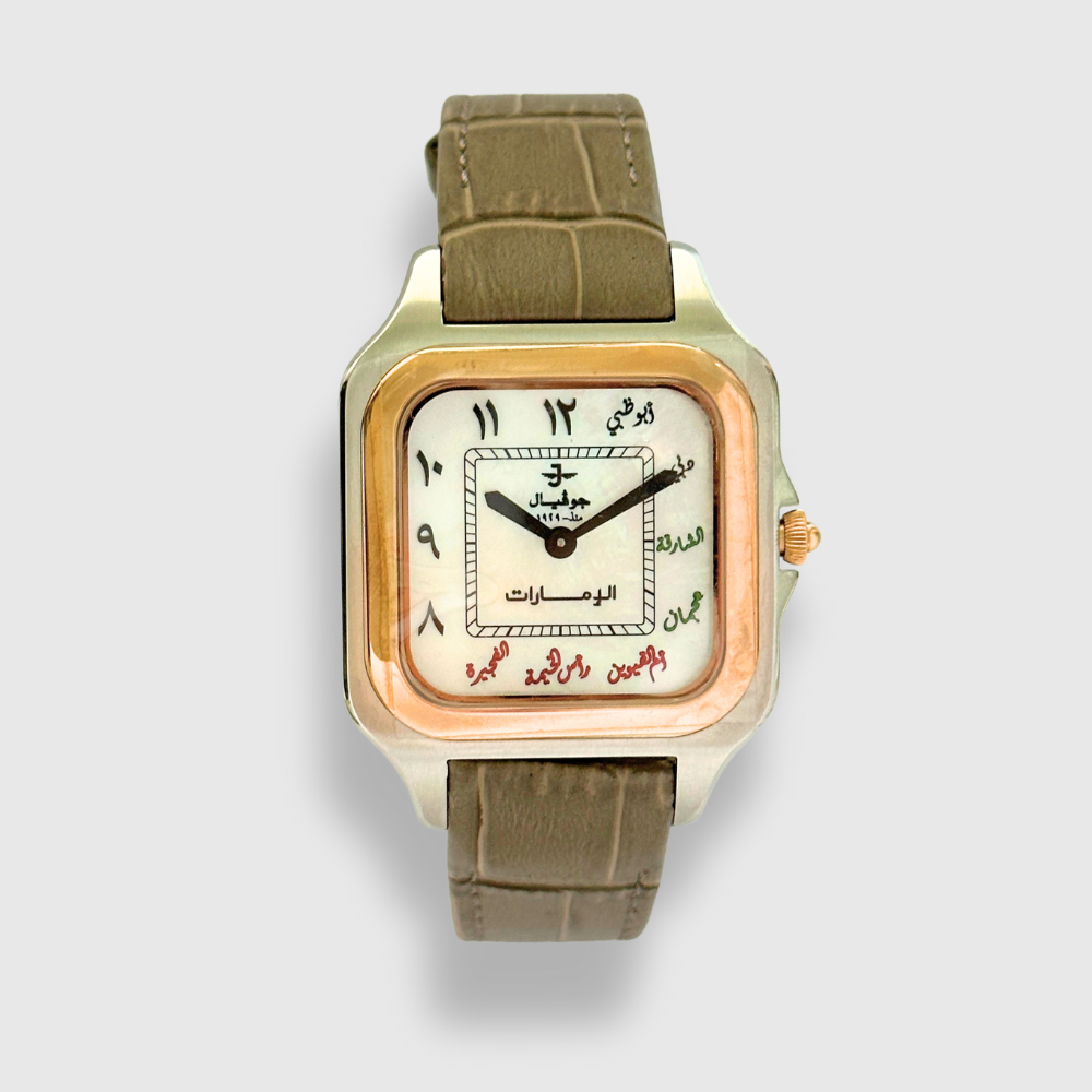 Watch with gold case and olive green strap on a light gray background