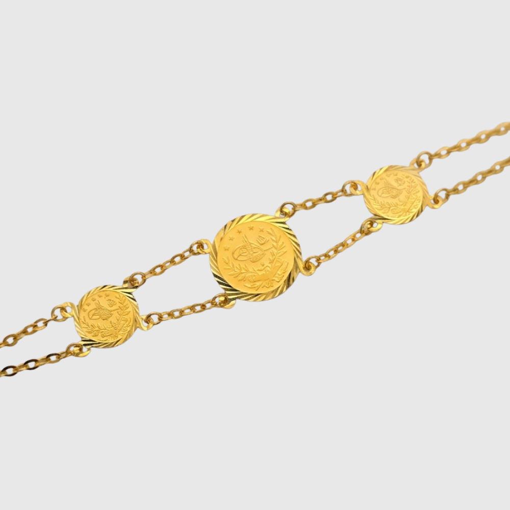 Gold bracelet with circular links on a light gray background