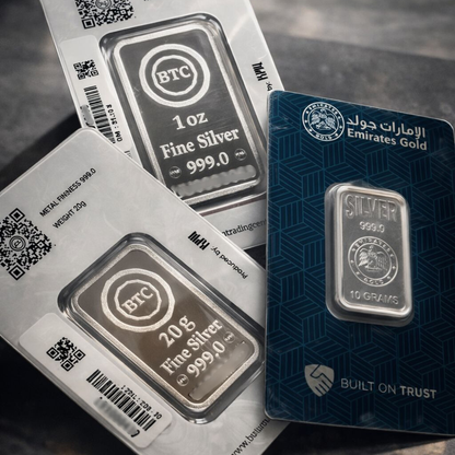 Silver bars in packaging with visible branding on a dark surface