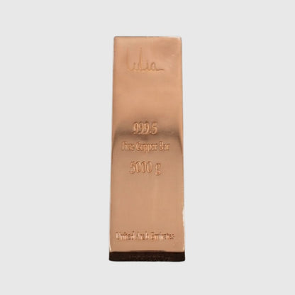 A 5000 g fine copper bar, 999.5 purity, featuring a polished rose gold metallic finish with an embossed signature and specifications, set against a plain light gray background.