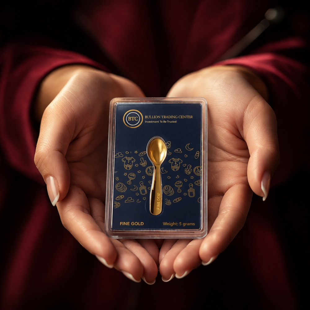 Gold spoon in a packaging held by hands against a dark background