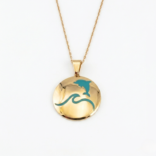 That's so summer - lulia jewelry Gold necklace with a round pendant featuring a dolphin and wave design on a white background